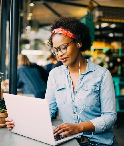 A woman working on a laptop at a coffee shop